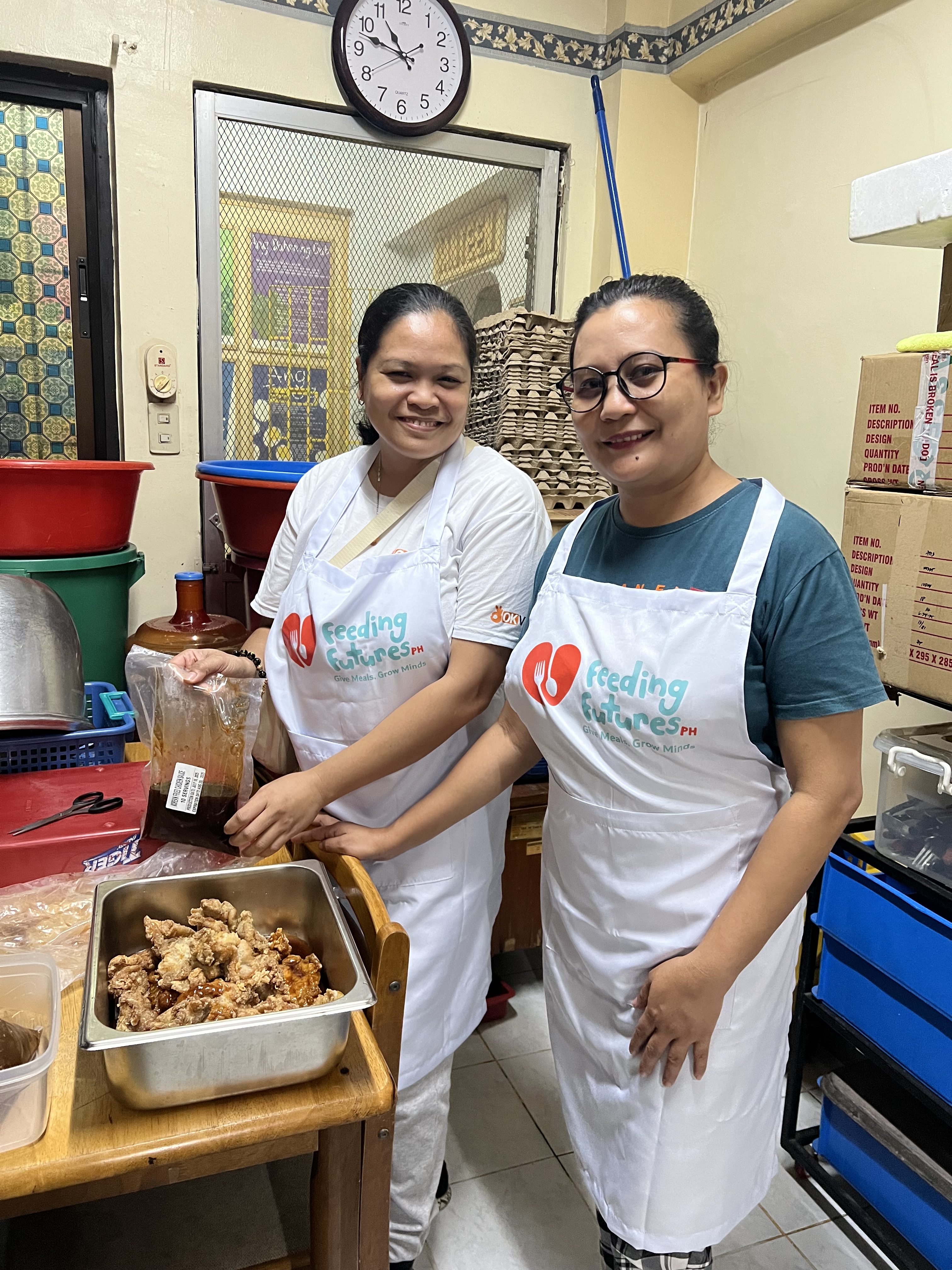 Volunteers preparing crispy pork for the children's meals.