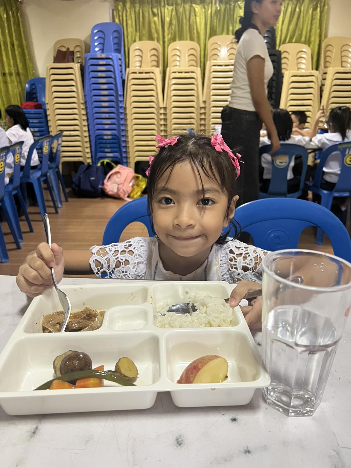 A young girl smiling with her tray of food