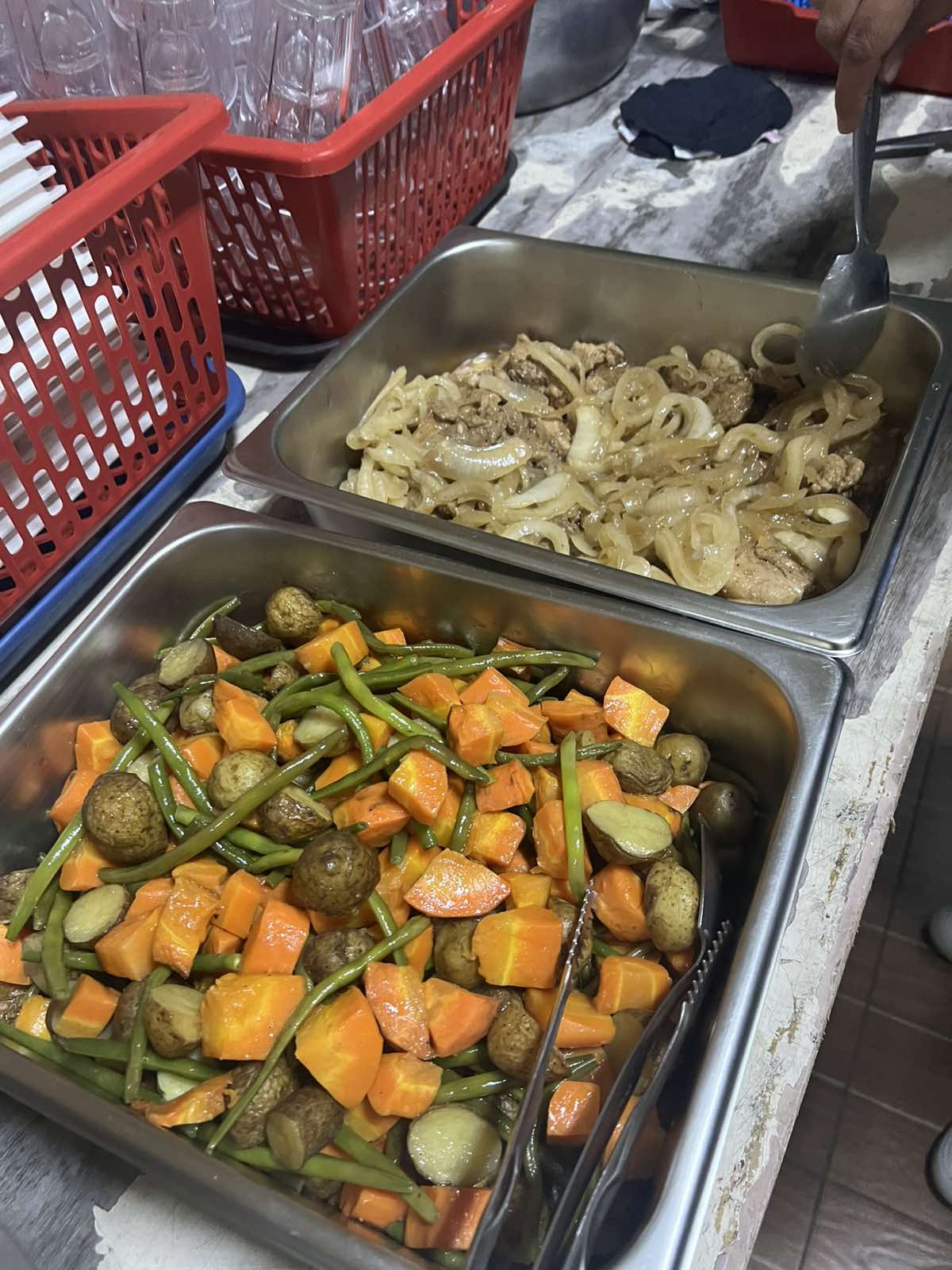 Hot, nourishing trays of pork steak with onions, and sautéed green beans, carrots, and potatoes