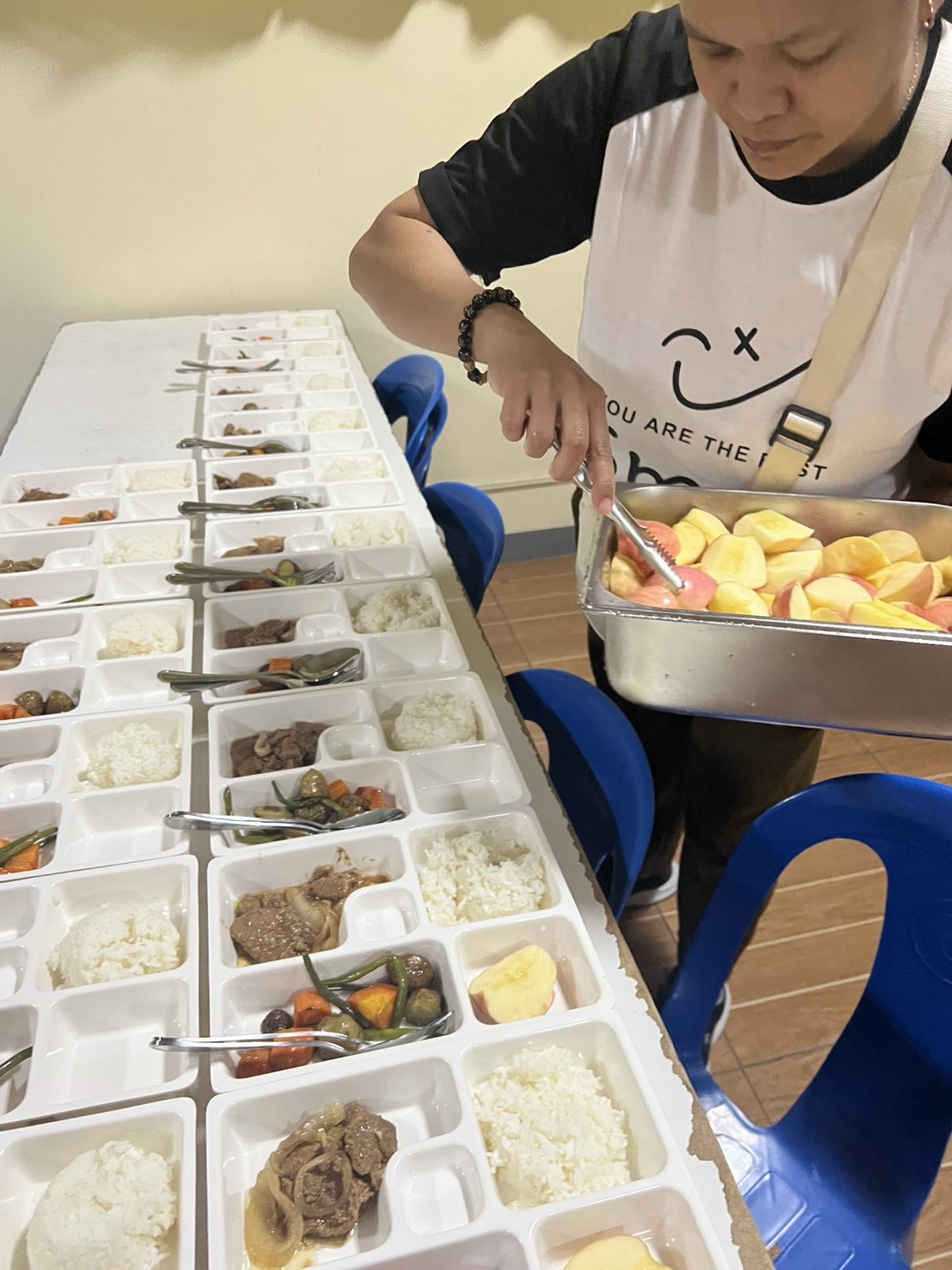A volunteer carefully plating fresh apple slices